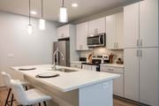 Daytona Beach apartment for rent - A kitchen with a white countertop and white chairs.