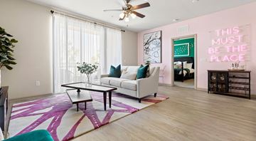 Tampa apartment for rent - A living room with a white couch and a pink rug.