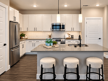 Knoxville apartment for rent - A kitchen with white cabinets and a large island with three stools.