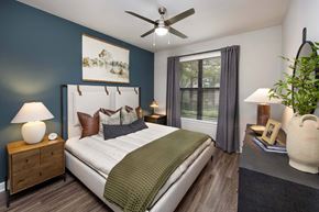 Decatur apartment for rent - Luxury Apartments in Decatur, GA, With In-Unit Washer and Dryer - Reserve Decatur - Bedroom With Teal Accent Wall, Designer Plank Flooring, Bedside Lamps, Ceiling Fan, and Large Window.
