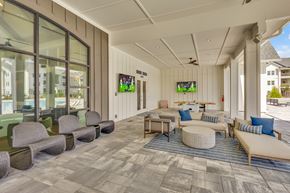 Fort Walton Beach apartment for rent - A spacious room with a long couch and a round ottoman in the center.
