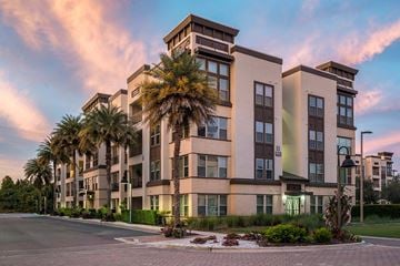 Altamonte Springs apartment for rent - A large building with a palm tree in front of it.