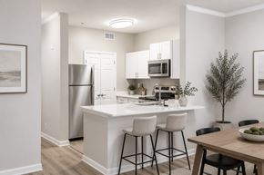 Fairburn apartment for rent - A modern kitchen with white cabinets and a wooden table.