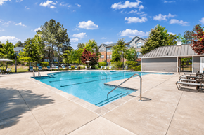 Fairburn apartment for rent - A large outdoor swimming pool surrounded by a concrete patio and a metal fence.