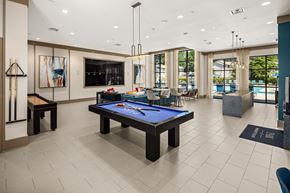 Sandy Springs apartment for rent - A billiard table is in the middle of a room with a pool table and a bar.