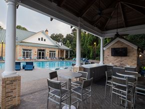Atlanta apartment for rent - A patio with a table and chairs overlooking a pool.