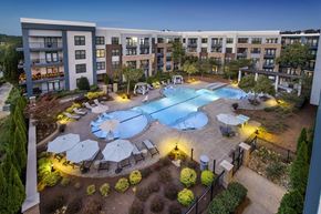 Decatur apartment for rent - A swimming pool surrounded by a patio with chairs and umbrellas at a resort.