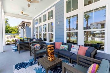 Beaufort apartment for rent - A patio with a couch, chairs, and a table with a pineapple on top.