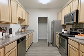 Memphis apartment for rent - A kitchen with wooden cabinets and a black fridge.