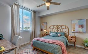 Hialeah apartment for rent - A bedroom with a bed, a chair, and a ceiling fan.