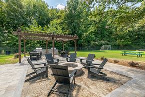 Norcross apartment for rent - A wooden pergola is surrounded by chairs and a table in a park.