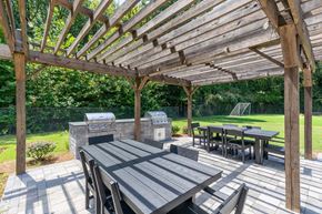 Norcross apartment for rent - A wooden pergola with a table and chairs underneath it.