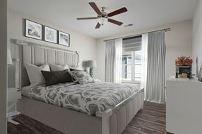 Lenoir City apartment for rent - A bedroom with a large bed and a ceiling fan.