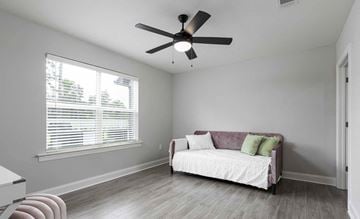 Titusville apartment for rent - A living room with a white couch and a ceiling fan.