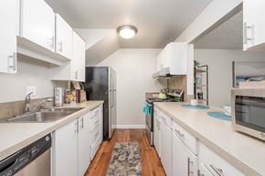Bellevue apartment for rent - A kitchen with white cabinets and a black refrigerator.
