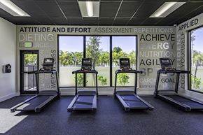 Goulds apartment for rent - Three treadmills in a gym with words like "achieve" and "energy" on the wall.