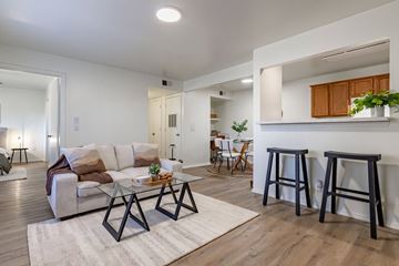 Benton apartment for rent - a living room with a couch and stools in front of a kitchen