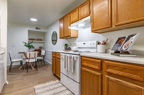 Benton apartment for rent - an open kitchen with wooden cabinets and a dining room with a table and chairs
