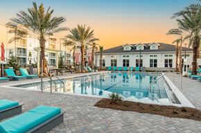 Santa Rosa Beach apartment for rent - A pool surrounded by palm trees and lounge chairs.