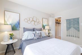 Ashburn apartment for rent - A bedroom with a large bed and a painting on the wall.