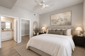Sunrise apartment for rent - A bedroom with a large bed and a painting on the wall.