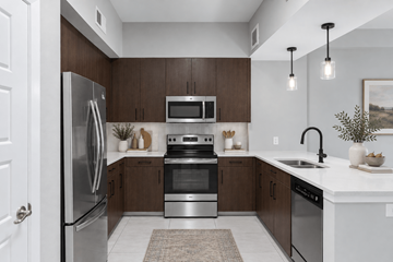 Sunrise apartment for rent - A modern kitchen with a refrigerator, oven, microwave, and sink.
