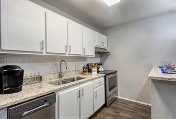 Riverview apartment for rent - A kitchen with white cabinets and a black coffee maker.
