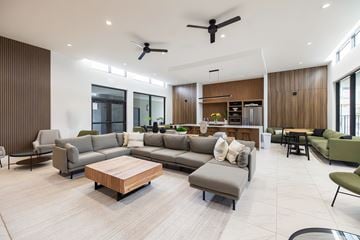 Goulds apartment for rent - A modern living room with a large grey sofa and a wooden coffee table.