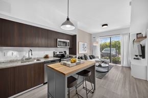 Goulds apartment for rent - A modern kitchen with dark wood cabinets and a white countertop.