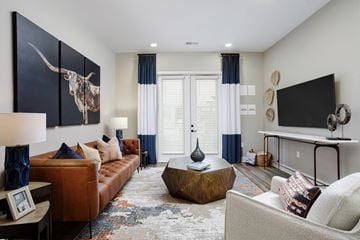 Smyrna apartment for rent - A living room with a brown couch, a coffee table, and a large painting of a bull.