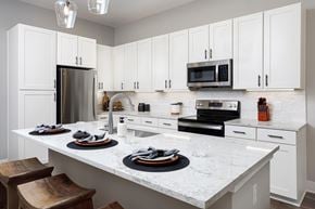 Smyrna apartment for rent - A kitchen with white cabinets and a marble countertop.