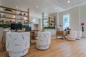 Gainesville apartment for rent - A modern office space with white furniture and wooden shelves.