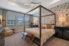 Gainesville apartment for rent - A bedroom with a four poster bed and a window with blinds.