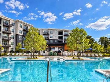 Sugar Hill apartment for rent - A large swimming pool in front of a multi-story apartment building.
