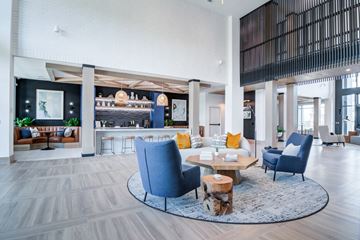 Sugar Hill apartment for rent - A modern living room with a blue chair and a coffee table.