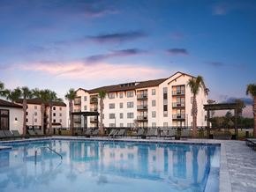 Panama City apartment for rent - a swimming pool at dusk with an apartment building in the background