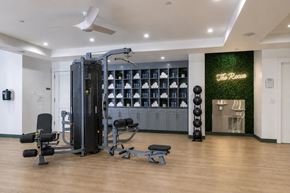 Atlanta apartment for rent - A gym with a variety of equipment including a squat rack, bench, and weights.