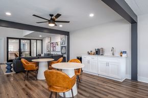 Daytona apartment for rent - A modern dining room with a white table and orange chairs.
