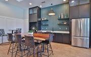 Mauldin apartment for rent - A kitchen with a table and chairs in the foreground and a refrigerator in the background.