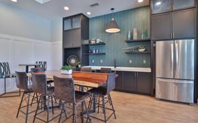 Mauldin apartment for rent - A kitchen with a table and chairs in the foreground and a refrigerator in the background.