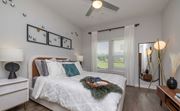 Mauldin apartment for rent - Apartments for Rent in Downtown Greenville, SC - The Aster - Bright Bedroom With White Bedding, Vinyl Plank Flooring, Ceiling Fan, Large Windows, and Modern Accent Lighting.