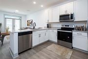 Huntsville apartment for rent - Huntsville, AL, Apartments Near Top Golf - The Kelvin - A Kitchen with White Shaker-Style Cabinets, Stainless Steel Appliances, and Recessed Ceiling Lighting.