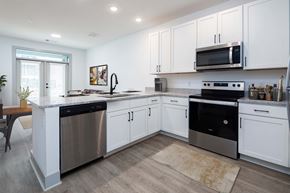 Huntsville apartment for rent - Huntsville, AL, Apartments Near Top Golf - The Kelvin - A Kitchen with White Shaker-Style Cabinets, Stainless Steel Appliances, and Recessed Ceiling Lighting.