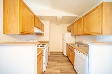 Highlands Ranch apartment for rent - A kitchen with wooden cabinets and white appliances.