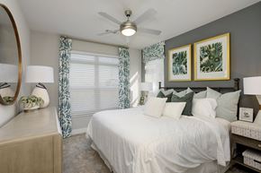 Antioch apartment for rent - A bedroom with a white bed and green pillows.