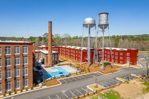 Warrenville apartment for rent - A red brick building with a water tower and a pool.