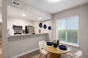 Sandy Springs apartment for rent - A kitchen with a table and chairs by a window.
