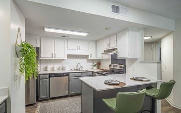 Columbia apartment for rent - A kitchen with a green chair and a plant hanging on the wall.