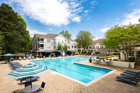 Atlanta apartment for rent - A large swimming pool surrounded by lounge chairs and umbrellas.