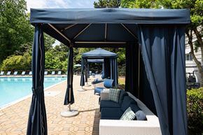 Atlanta apartment for rent - A poolside canopy with blue umbrellas and a couch.